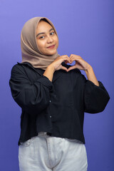 Asian Muslim Woman Pose with Love Symbol with Hands, Isolated on Purple Background