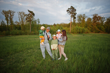 Naklejka na ściany i meble Parents with three kids having fun together at meadow.