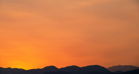 Orange sky over silhouette mountain in the morning.