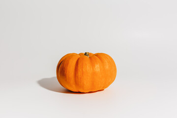 Obraz premium Fresh ripe orange pumpkin on white background. Space for text mockup Halloween concept