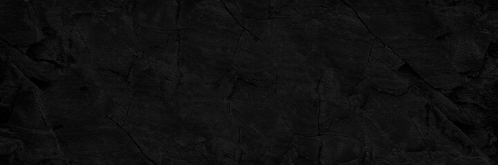 Black stone texture. Old rough cracked wall surface. Close-up. Dark grunge background, backdrop with space for design. Banner. Wide. Long. Panoramic. Template. Empty.