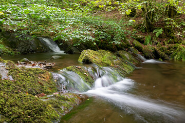 Long exposure of a waterfall on the Horner Water river in Horner woods in Somerset