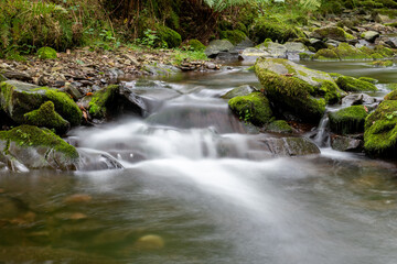 Long exposure of a waterfall on the Horner Water river in Horner woods in Somerset