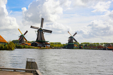 Naklejka premium Billowing clouds in the background of historic dutch windmills in Netherlands once know as Holland. 