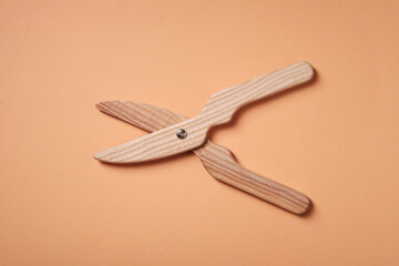 Children's wooden pruner on an orange background, toy