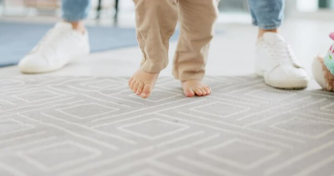 Parent, hold and baby while learning to walk in living room for muscle, motor skill and coordination. Child, mom or dad in home teaching balance, walking and infant development for movement in house