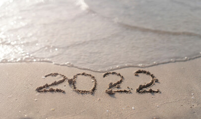 The numbers 2022 are washed away by the sea waves of the Persian Gulf. The concept of a change of years