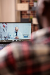 Young adult talking to doctor on videocall, using remote telemedicine videoconference with medic. Chatting about healthcare at online telehealth appointment, teleconference call.