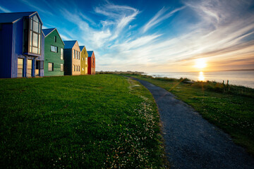 Bunte H&auml;user im Sonnenuntergang vor Meer
