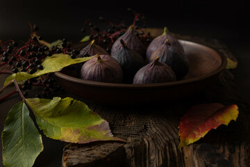 Still life with figs. Figs in a plate on a wooden table.