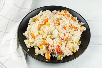 Rice with vegetables in a plate on the table.