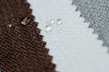 Close up water drop on gunny textile. Bright collection of gunny textile samples. Fabric texture background.