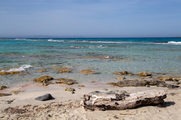 Rocky beach with a turquoise blue sea and waves in spain