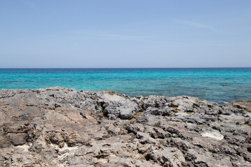 Rocky beach with a turquoise blue sea and waves in spain