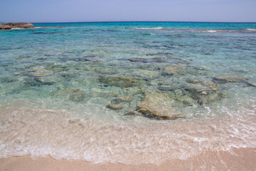 Rocky beach with a turquoise blue sea and waves in spain
