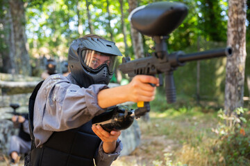 Fototapeta premium Paintball player recklessly aims with a gun on the battlefield