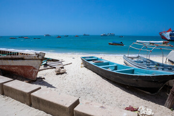 Fototapeta na wymiar Vintage boats lying on the snow-white beach of the island of Zanzibar. 