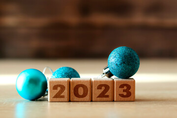 Wooden cubes with the numbers 2023, balls with tinsel. Celebrating New Year and Christmas. Winter holidays. Christmas decorations. Copy space