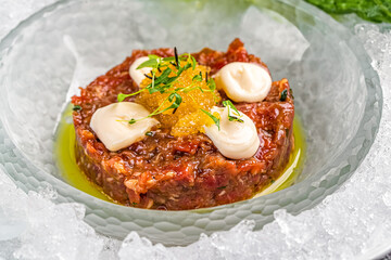 tartare with caviar in a plate on ice in a restaurant