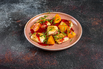 persimmon dish with baked cheese on a dark background in a restaurant