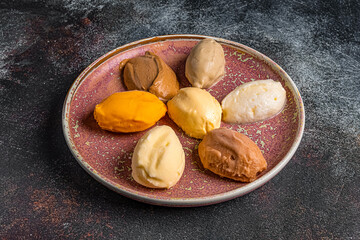 assorted ice cream on a plate on a dark background in a restaurant