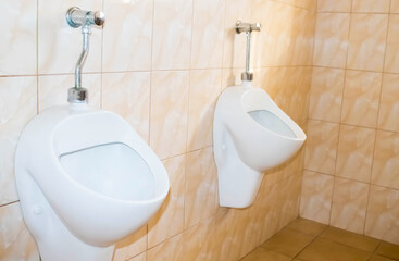 Fototapeta premium Close up used modern white urinal in the toilet.Sanitary of men toilet concept.