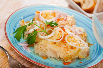 Plate with appetizing sauerkraut, carrots and onion. Traditional russian dish