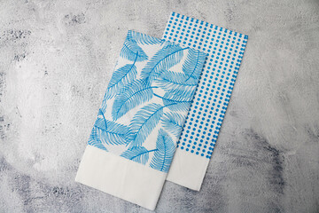 Two blue tissues of different prints on a light background. Mention the sustainable party, replacement of plastic in people's routine and get-togethers for actions in support of the environment.