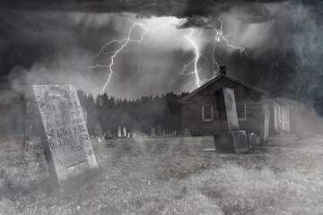 An old church and its graveyard, seen here under a stormy night sky and enveloped in mist, are all...
