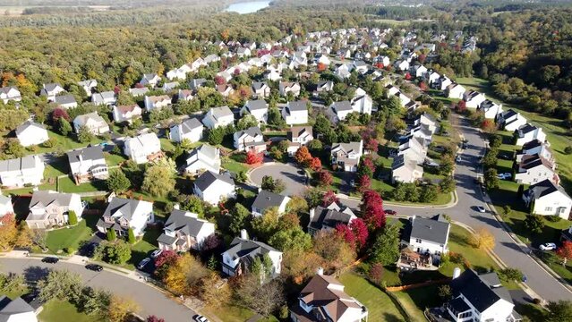 Neighborhood of modern single-family houses of the upper and middle class. The streets are full of greenery. Autumn landscape from a drone.