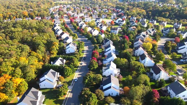 Neighborhood of modern single-family houses of the upper and middle class. The streets are full of greenery. Autumn landscape from a drone.