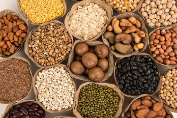 Many cereals such as walnuts, macadamia, green peas, almonds and others isolated on white background.