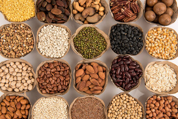 Many cereals such as walnuts, macadamia, green peas, almonds and others isolated on white background.