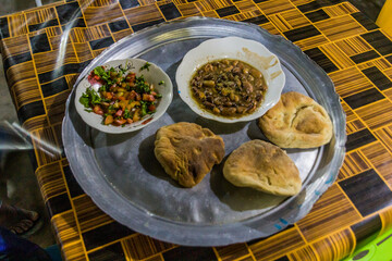 Traditional meal in Sudan - fuul (stew of cooked fava beans), salad and bread.