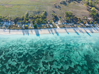 An expanse of sand and seagrass fringes a beautiful beach on the island of Pantar, Indonesia. This region is known for its high marine biodiversity and spectacular scuba diving and snorkeling. © ead72