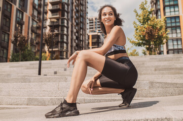 Pretty dark-haired girl in sportswear feeling good after workout