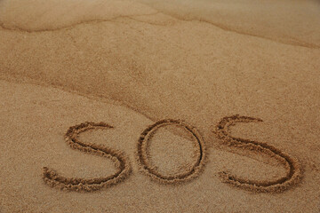 Message SOS drawn on sandy beach, space for text