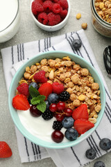 Flat lay composition with tasty granola and berries on light grey table. Healthy meal