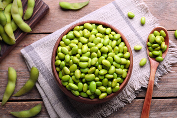 Delicious edamame beans on wooden table, flat lay