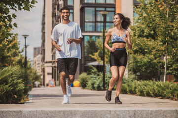 Two young people in sportswear running together