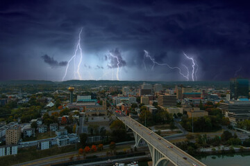 aerial shot of the skyscrapers, office buildings and bridges in the city skyline with cars driving and storm clouds and lightning in Knoxville Tennessee USA - obrazy, fototapety, plakaty