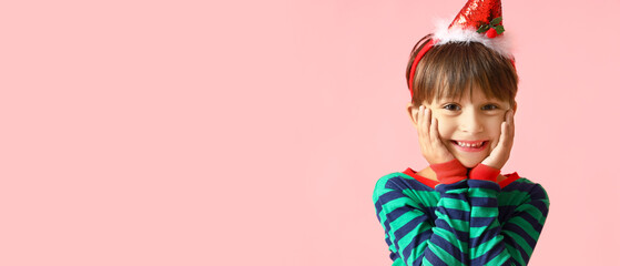 Happy little boy in Christmas costume on pink background with space for text
