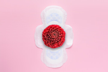 Menstrual pad with red flower on pink background © Pixel-Shot