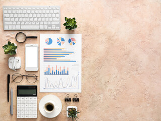 Business charts, mobile phone and stationery on beige background