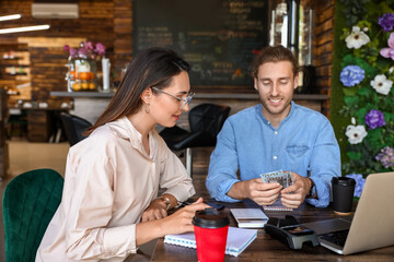 Young business owners working at table in their cafe