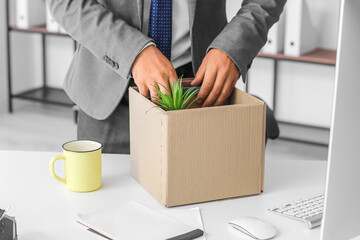 Fired young man packing his stuff in office, closeup