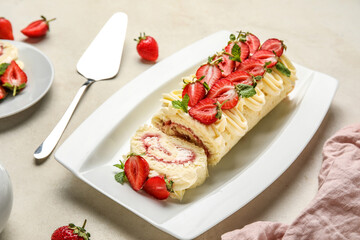 Fototapeta na wymiar Plate with delicious strawberry roll cake on table