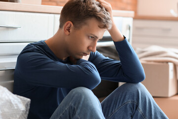 Stressed young man in kitchen, closeup