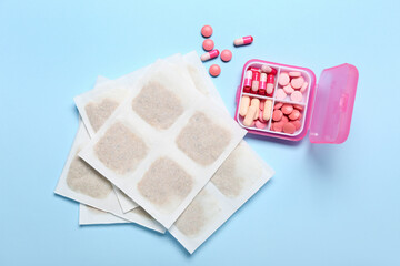 Mustard plasters and pills on blue background