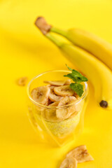 Glass of tasty chia seed pudding with banana on yellow background